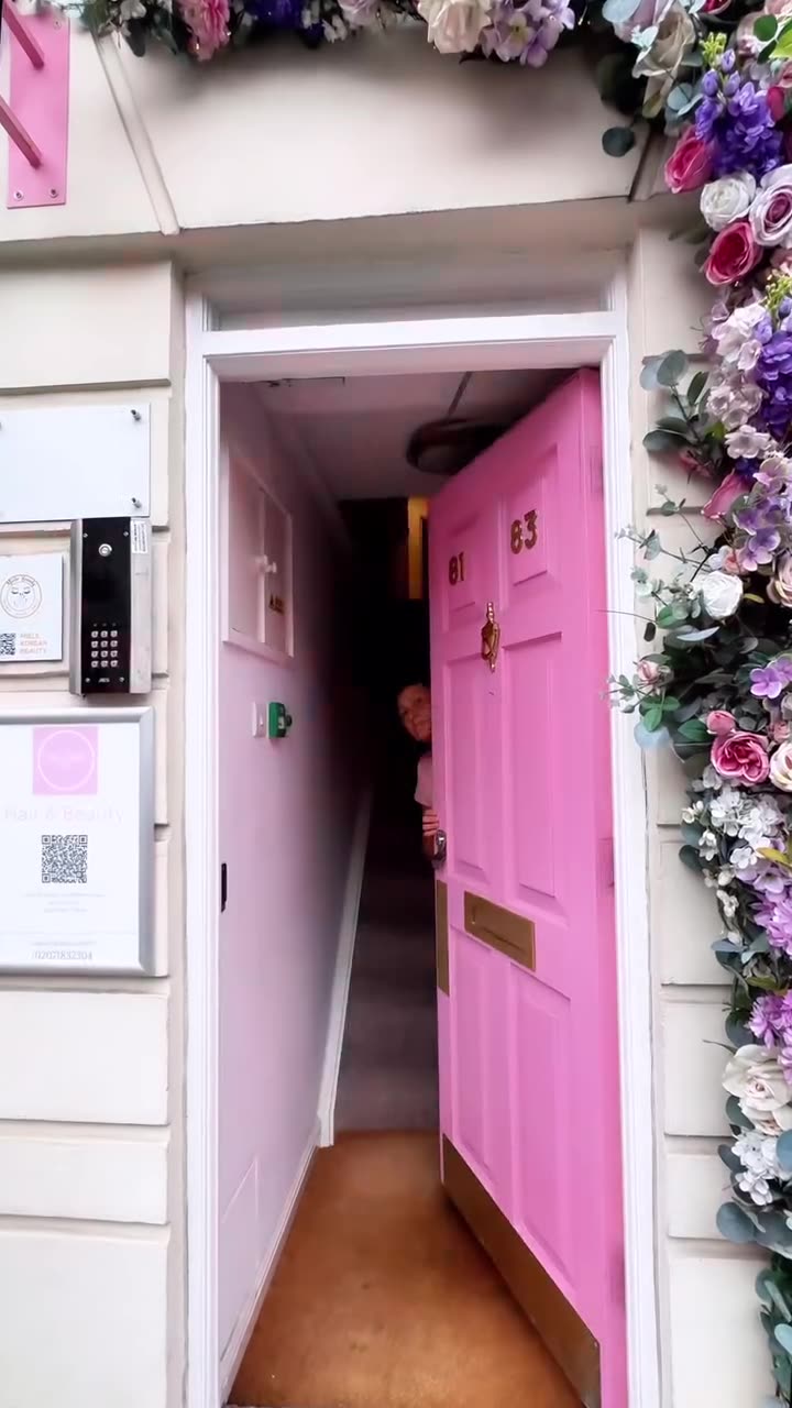 Pink front door framed with flowers
