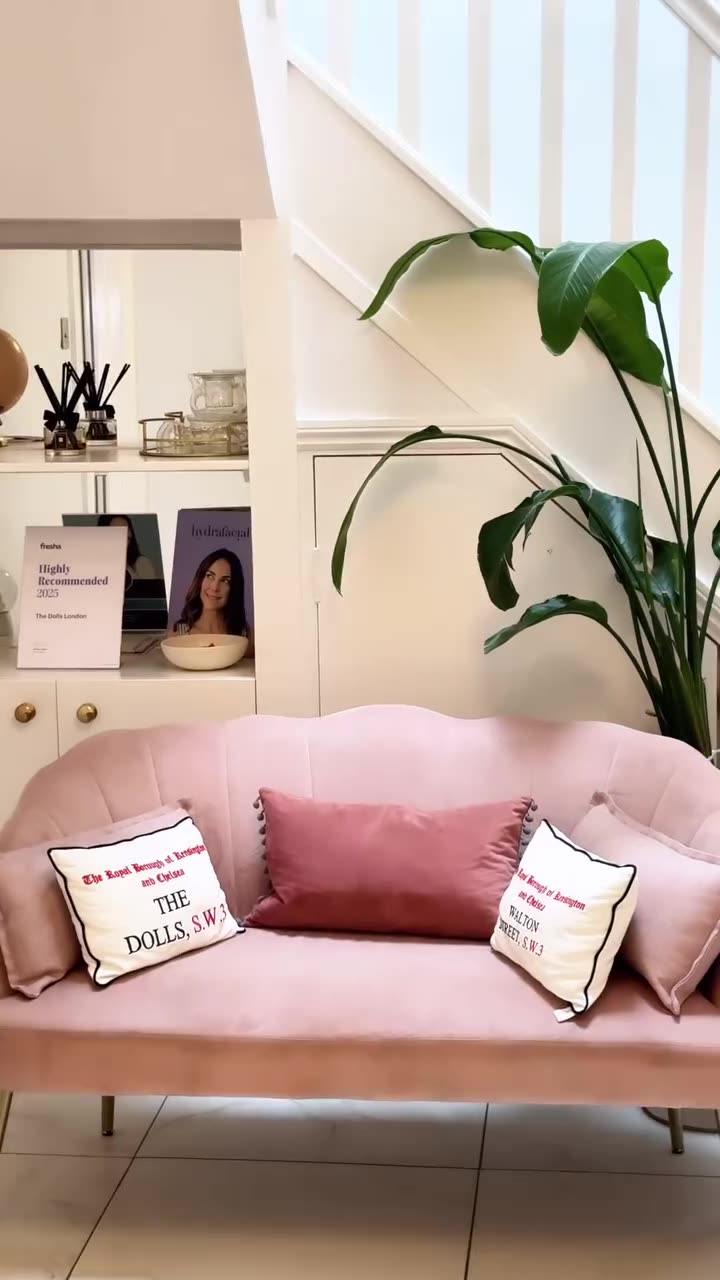 Pink sofa and cushions beside a staircase