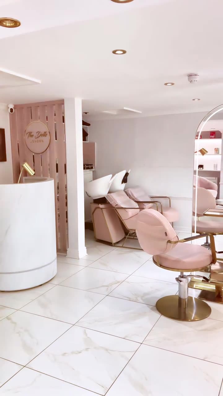 Reception desk with a pink salon chair beyond