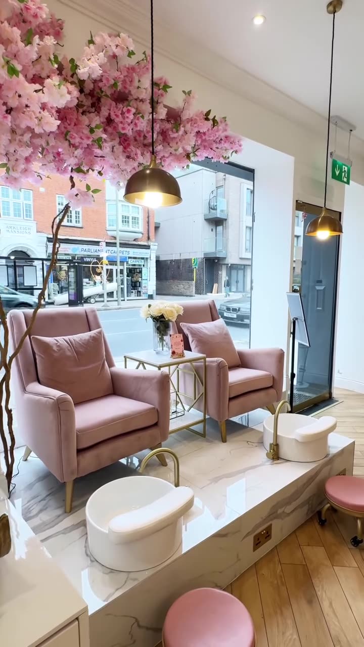 Pink armchairs under pink blossom by a window