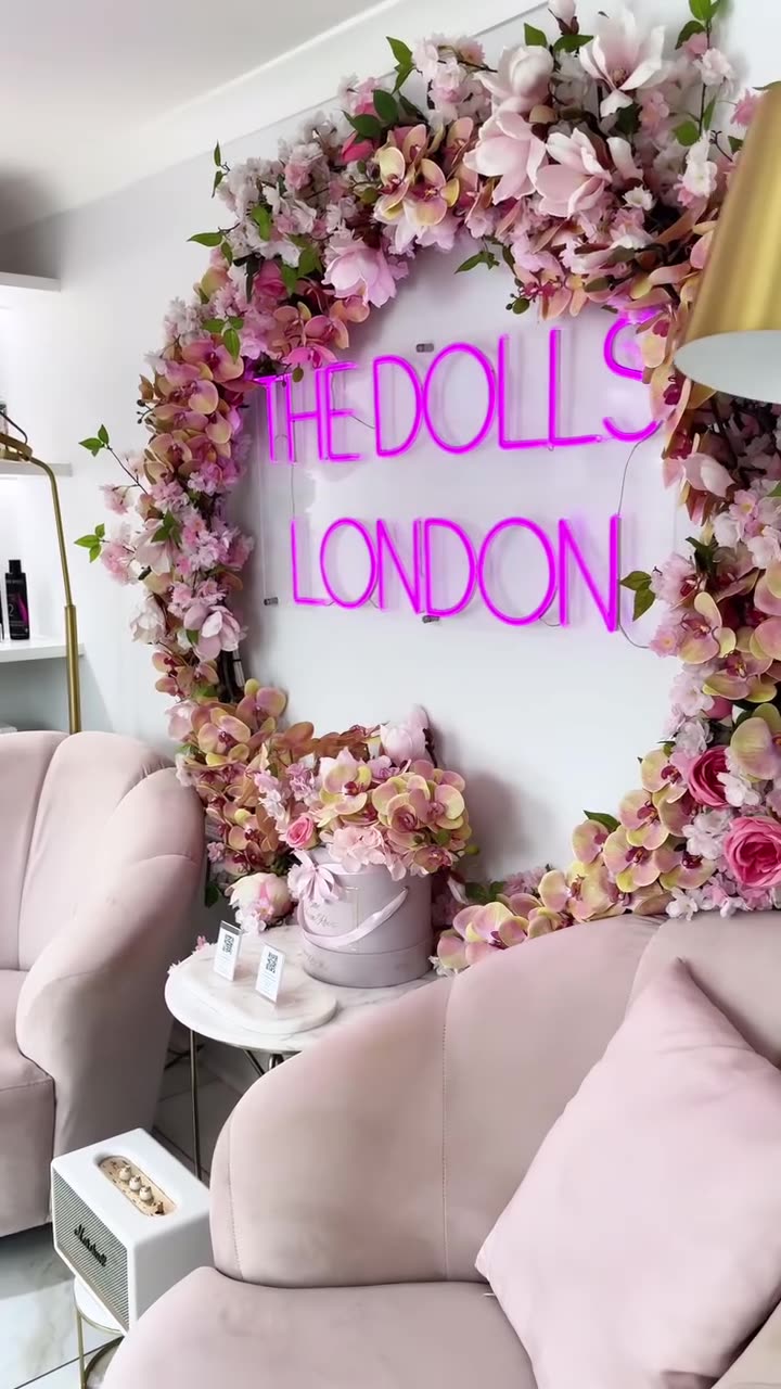 The Dolls London neon sign framed in pink flowers